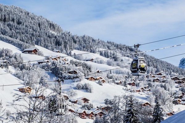Station de ski La Clusaz, paysage montagneux et enneigé avec pistes de ski et chalets.