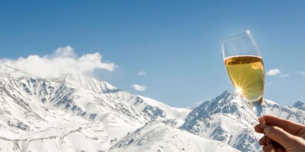 Celebration with champagne at foot of the snowy Alps.