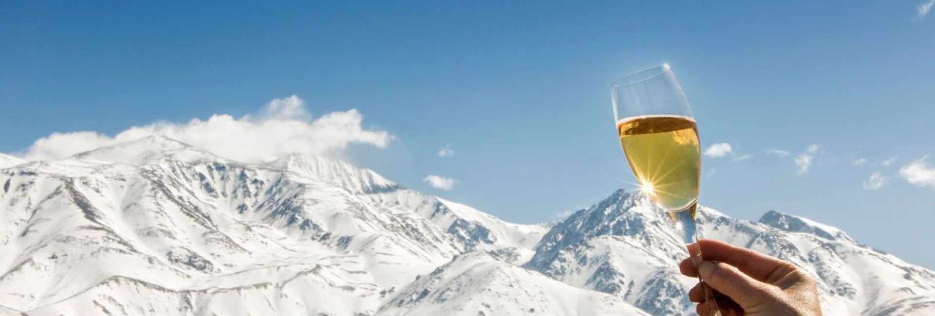 Celebration with champagne at foot of the snowy Alps.