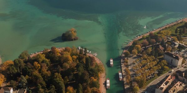 Drone aerial view of France travel and landmarks. Romantic, beautiful old town of the famous destination Annecy at sunset, with medieval architecture