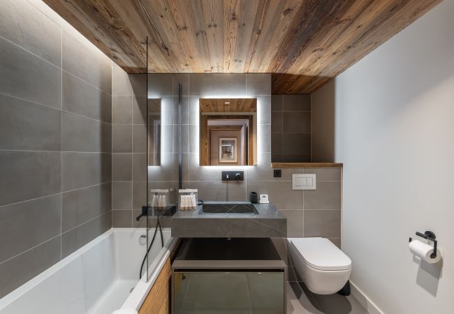 Salle de Bain de Luxe avec Baignoire et Toilettes - Ambiance Relaxante dans un Appartement de Ski à Méribel