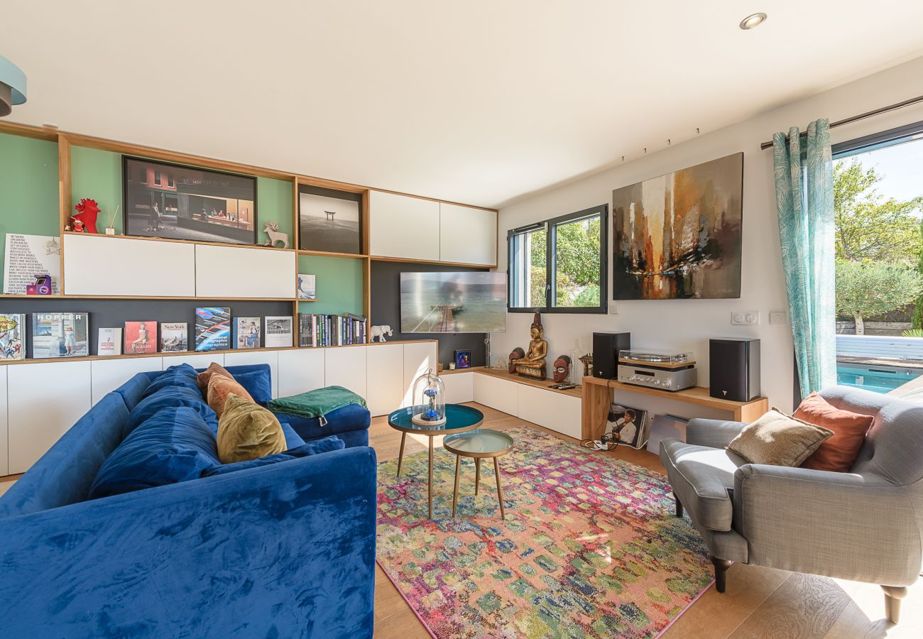 Villa Sunset : salon équipé d’une bibliothèque, TV et chaîne hi-fi avec platine vinyle.