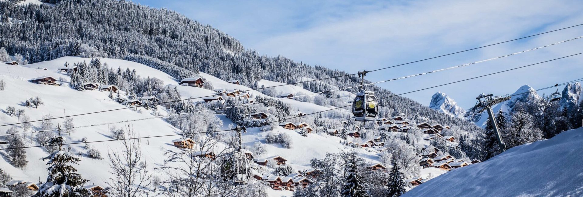 Station de ski La Clusaz, paysage montagneux et enneigé avec pistes de ski et chalets.